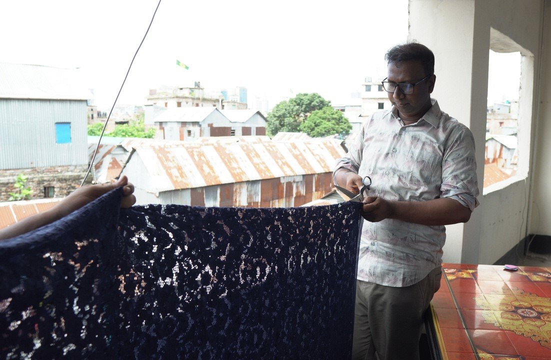 Inspecting a length of navy sequinned lace on the studio veranda